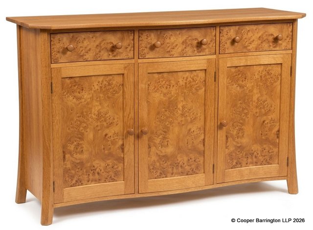 Fine Peter Hall of Staveley Arts & Crafts Style Handcrafted Burr Walnut Sideboard.  20th Century. The shaped top over three drawers and three cupboards opening to reveal a shelved interiour all raised on splayed legs. Peter Hall monogram carved to side. Height 35.5 In, Width 55.5in, Depth 21inches.
